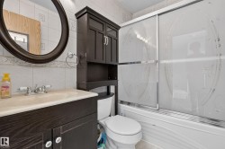 Vanity with integrated sink, chrome faucet, and dark wood-finish cabinetry - 