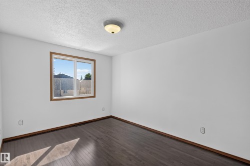 Dark wood-finish flooring with coordinating baseboards - 23 Willowdale Place Nw, Edmonton, AB 