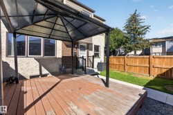 Private deck with an overhead gazebo structure, fenced yard, and exterior stucco finish - 