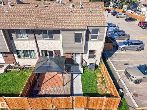 Rear exterior featuring a wood deck with a gazebo, fenced yard with grass, brown shingle roof, and exterior siding - 23 Willowdale Place Nw, Edmonton, AB 