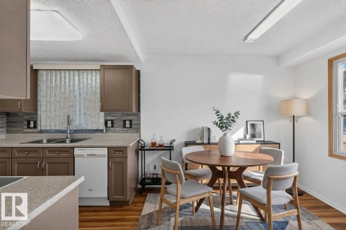 Kitchen featuring wood-finish cabinetry, light-toned countertops, and a tiled backsplash - 23 Willowdale Place Nw, Edmonton, AB 