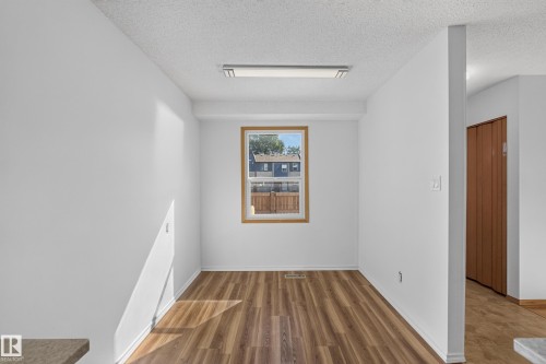 Wood-finish flooring with a natural wood window frame and white walls - 23 Willowdale Place Nw, Edmonton, AB 