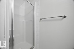 Shower enclosure with a clear glass door, chrome hardware, and white tile surround - 