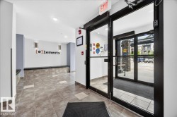 Lobby entrance featuring light-toned tile flooring, recessed lighting, and a modern accent wall with sconce lighting - 