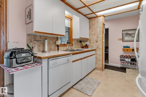 White cabinetry, laminate countertops, integrated dishwasher, tiled backsplash, and recessed ceiling lighting - 13432 134 Street Nw, Edmonton, AB - Indoor