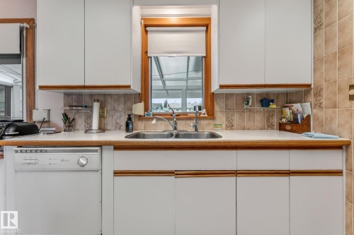 White cabinetry with wood trim accents - 13432 134 Street Nw, Edmonton, AB - Indoor Photo Showing Kitchen With Double Sink