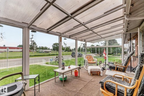 Enclosed sunroom featuring a translucent roof, full-height glass panels, a carpeted floor, and a white aluminum frame - 13432 134 Street Nw, Edmonton, AB - Outdoor With Deck Patio Veranda With Exterior