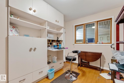 Built-in cabinetry with integrated desk space, wood-finish flooring, and a triple-pane window with wood trim - 13432 134 Street Nw, Edmonton, AB - Indoor
