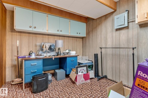 Wood-paneled walls and ceiling-mounted cabinetry with brass hardware - 13432 134 Street Nw, Edmonton, AB - Indoor