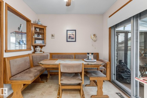 Built-in wood-finish banquette seating, wood-finish flooring, and a sliding glass door - 13432 134 Street Nw, Edmonton, AB - Indoor Photo Showing Dining Room