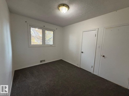 Interior room featuring carpet flooring, white walls, and a window with white trim - 9733 143 Street Nw, Edmonton, AB - Indoor Photo Showing Other Room