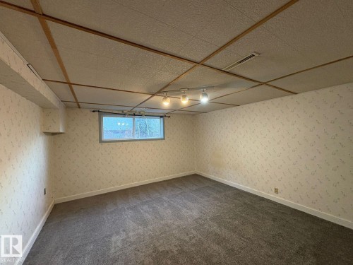 Patterned wallpaper, recessed window, track lighting fixture, drop ceiling, and gray carpeting - 9733 143 Street Nw, Edmonton, AB - Indoor