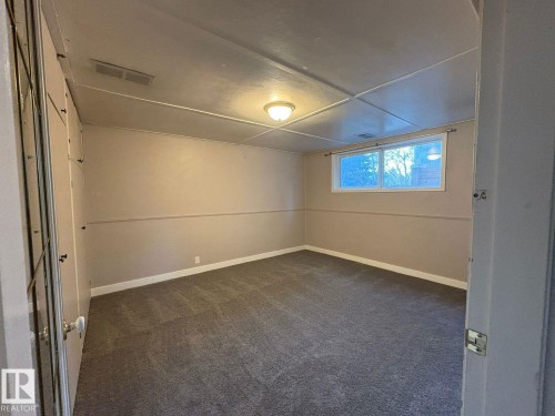 Neutral-toned carpeting and walls, recessed ceiling panels, and an overhead flush-mount light fixture - 9733 143 Street Nw, Edmonton, AB - Indoor Photo Showing Other Room
