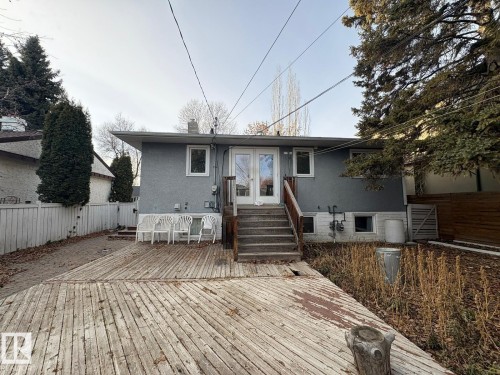 Exterior featuring gray stucco siding, a wood deck, and white framed windows - 9733 143 Street Nw, Edmonton, AB - Outdoor