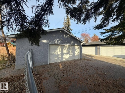 Detached garage structure with stucco siding and a white panel garage door - 9733 143 Street Nw, Edmonton, AB - Outdoor