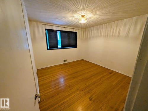 Hardwood flooring, painted walls, window with blinds, ceiling-mounted light fixture - 9733 143 Street Nw, Edmonton, AB - Indoor Photo Showing Other Room