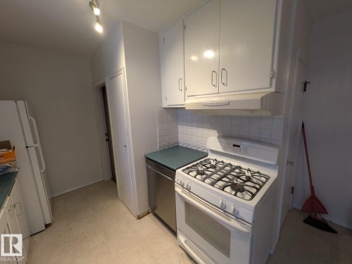 Kitchen featuring white cabinetry, a gas range, a stainless steel dishwasher, and track lighting - 9733 143 Street Nw, Edmonton, AB - Indoor Photo Showing Kitchen