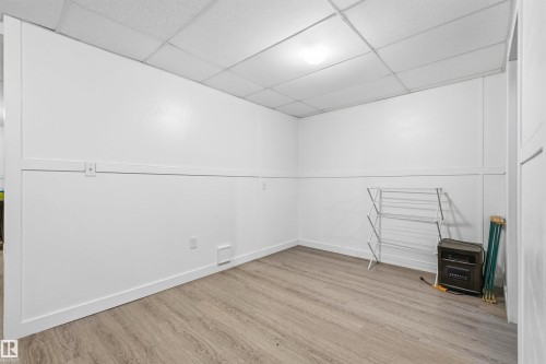 Wood-finish flooring, white walls, and a white grid ceiling - 21207 90 Ave Nw, Edmonton, AB - Indoor Photo Showing Other Room
