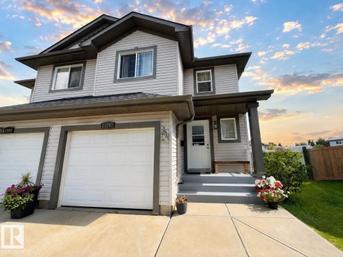 Two-story residence featuring siding exterior, a front entry, a single-car garage, an additional garage, and a concrete pathway - 21207 90 Ave Nw, Edmonton, AB - Outdoor