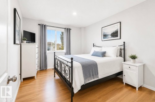 Recessed ceiling lighting, wood-finish flooring, and a large window with white trim - 21207 90 Ave Nw, Edmonton, AB - Indoor Photo Showing Bedroom
