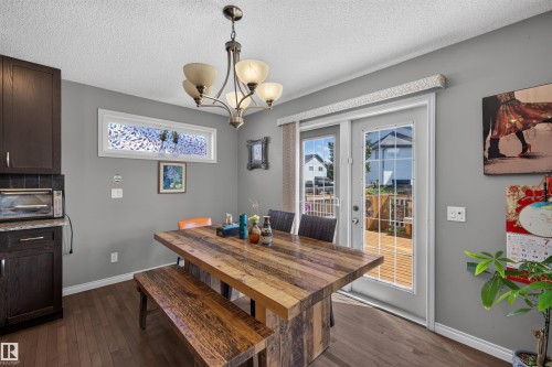 Wood-finish flooring, dark wood cabinetry, and a granite-style countertop - 16515 139 Street Nw, Edmonton, AB - Indoor Photo Showing Dining Room