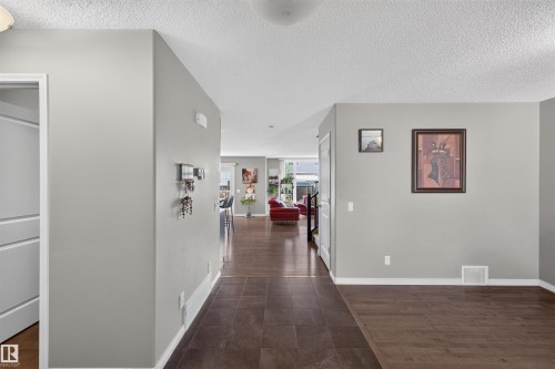 Wood-finish flooring throughout the main level, featuring tiled entry - 16515 139 Street Nw, Edmonton, AB - Indoor Photo Showing Other Room