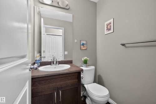 Vanity with a white oval sink, dark wood-finish cabinetry, and a countertop - 16515 139 Street Nw, Edmonton, AB - Indoor Photo Showing Bathroom
