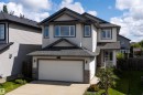Two-story residence featuring light-toned siding with dark trim, an attached two-car garage, and a concrete driveway - 16515 139 Street Nw, Edmonton, AB  - Outdoor With Facade 
