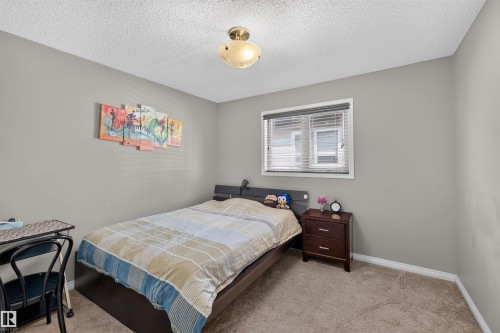 Neutral wall paint, ceiling-mounted light fixture, window with blinds, and carpeted flooring - 16515 139 Street Nw, Edmonton, AB - Indoor Photo Showing Bedroom