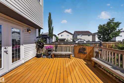 Expansive wood deck with built-in benches, double French doors, exterior wall lighting, and privacy fencing - 16515 139 Street Nw, Edmonton, AB - Outdoor With Deck Patio Veranda With Exterior
