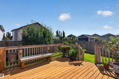 Spacious wood deck with railing, integrated bench seating, and direct access to a manicured lawn - 16515 139 Street Nw, Edmonton, AB - Outdoor With Deck Patio Veranda With Exterior