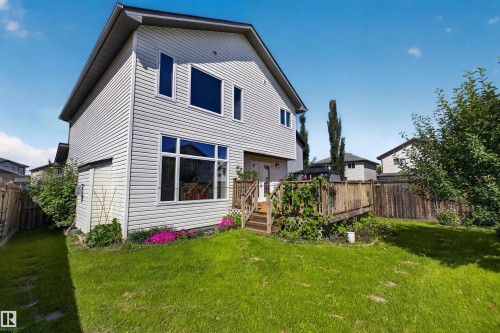 Two-story residence with light-colored siding, a multi-level wood deck, a fenced yard, and varied window styles - 16515 139 Street Nw, Edmonton, AB - Outdoor