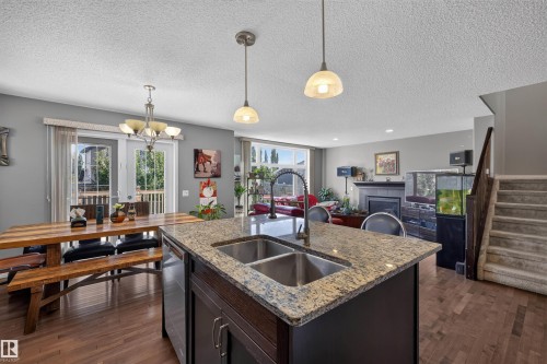 Kitchen island with dual stainless steel sinks and granite countertop - 16515 139 Street Nw, Edmonton, AB - Indoor Photo Showing Kitchen With Double Sink
