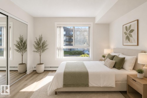 Bright room featuring a large window, wood-finish flooring, and mirrored closet doors - #226 17011 67 Av Nw, Edmonton, AB - Indoor Photo Showing Bedroom