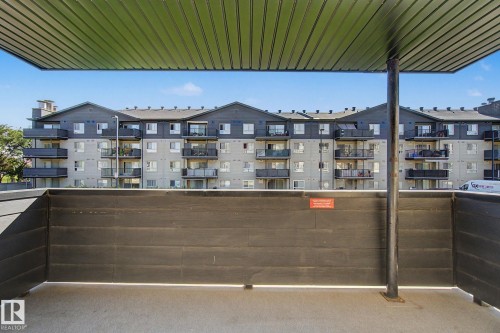 Outdoor covered concrete patio area with a privacy wall - #226 17011 67 Av Nw, Edmonton, AB - Outdoor With Balcony