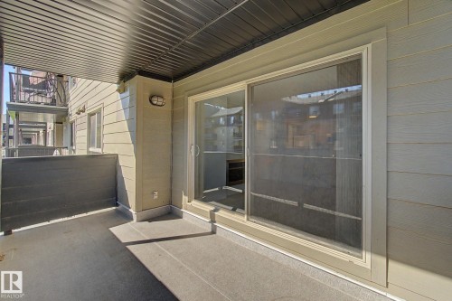 Private patio with a sliding glass door and durable concrete flooring - #226 17011 67 Av Nw, Edmonton, AB - Outdoor With Exterior