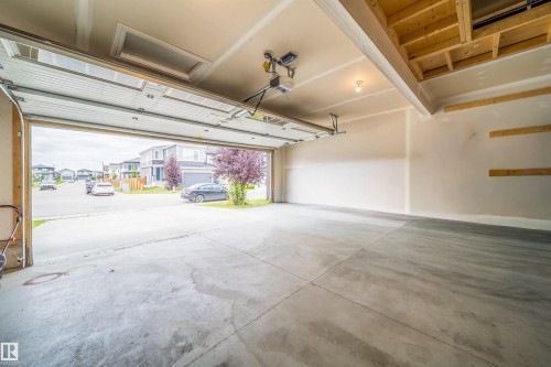 Attached garage with concrete flooring, automatic garage door opener, and exposed ceiling joists - 9903 222 Street Nw, Edmonton, AB 