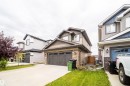 Two-story residence featuring a shingle and stone facade, an attached double garage, and a concrete driveway - 9903 222 Street Nw, Edmonton, AB 