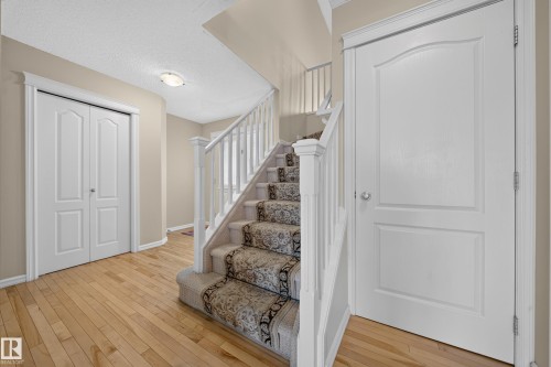 Hardwood flooring and carpeted staircase with white balusters - 2518 33A Avenue Nw, Edmonton, AB - Indoor Photo Showing Other Room