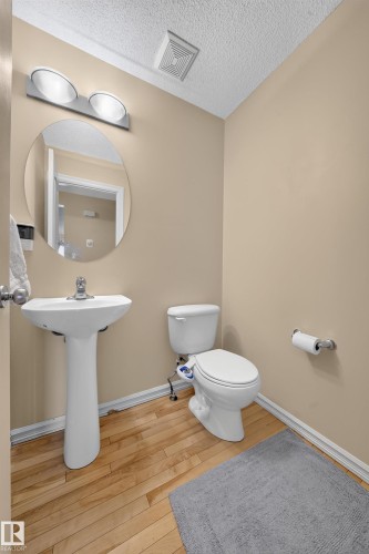 Light wood-finish flooring with white baseboards - 2518 33A Avenue Nw, Edmonton, AB - Indoor Photo Showing Bathroom