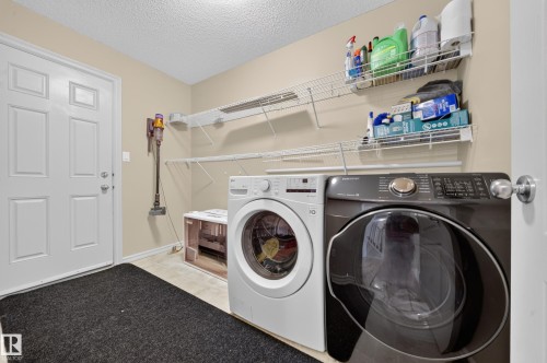 White paneled door, light-toned wall paint, tiled flooring, and wire shelving units - 2518 33A Avenue Nw, Edmonton, AB - Indoor Photo Showing Laundry Room