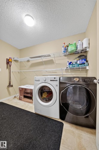 Laundry area featuring multiple wall-mounted wire shelves and tile flooring - 2518 33A Avenue Nw, Edmonton, AB - Indoor Photo Showing Laundry Room
