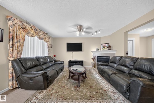 Living area with a fireplace, recessed lighting, ceiling fan, and a large window - 2518 33A Avenue Nw, Edmonton, AB - Indoor Photo Showing Living Room With Fireplace