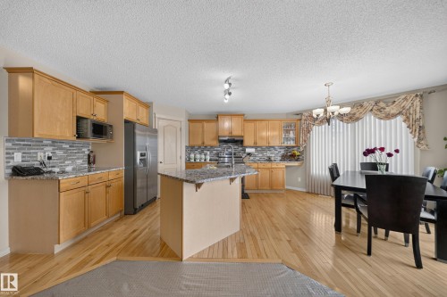 Kitchen featuring wood-finish flooring, light wood cabinetry, and a stone-finish countertop - 2518 33A Avenue Nw, Edmonton, AB - Indoor Photo Showing Kitchen