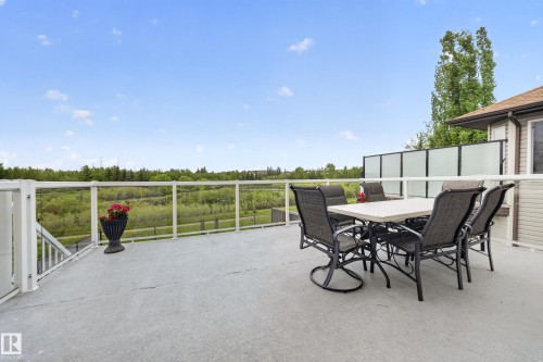 Expansive outdoor deck with glass panel railing and privacy screen - 2518 33A Avenue Nw, Edmonton, AB - Outdoor With Exterior