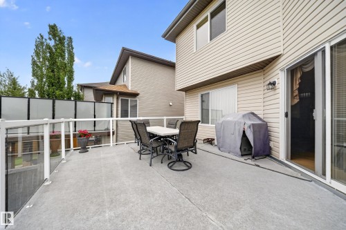 Expansive concrete deck featuring a frosted glass and aluminum railing system, with direct access to interior spaces via a sliding glass door - 2518 33A Avenue Nw, Edmonton, AB - Outdoor With Exterior