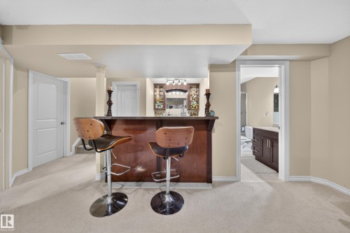 Built-in wet bar with wood-finish cabinetry, countertop, and shelving - 2518 33A Avenue Nw, Edmonton, AB - Indoor