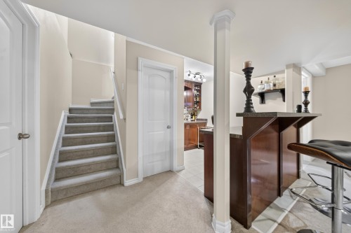 Built-in bar with a stone-finish countertop, wood-finish cabinetry, and recessed lighting - 2518 33A Avenue Nw, Edmonton, AB - Indoor Photo Showing Other Room