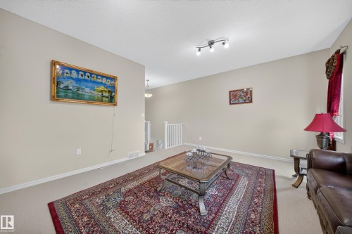 Neutral wall paint, track lighting, and a white staircase railing - 2518 33A Avenue Nw, Edmonton, AB - Indoor