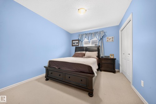 Carpeted flooring, window with blinds, white bi-fold closet doors, and ceiling-mounted light fixture - 2518 33A Avenue Nw, Edmonton, AB - Indoor Photo Showing Bedroom